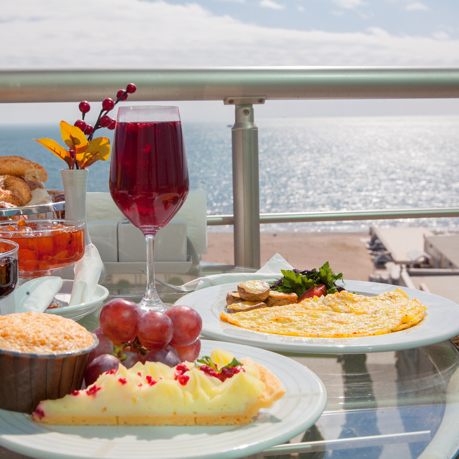 side-view-breakfast-with-baked-grape-omelette-white-plate-balc-ony-by-sea.jpg